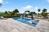 Salt chlorinated pool w/ water features, LED color changing light, sun shelf with umbrella hole and in water stools. Stone decking surrounds the pool