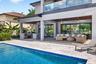 Salt chlorinated pool w/ water features, LED color changing light, sun shelf with umbrella hole and in water stools. Stone decking surrounds the pool