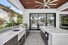 Covered patio w/ T&G ceilings, fans, fire pit seating and outdoor kitchen overlooks the gorgeous wide New River views and pool area