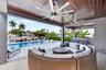 Covered patio w/ T&G ceilings, fans, fire pit seating and outdoor kitchen overlooks the gorgeous wide New River views and pool area
