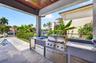 Outdoor kitchen w/ built in grill, refrigerator, ice maker and sink