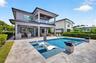 Salt chlorinated pool w/ water features, LED color changing light, sun shelf with umbrella hole and in water stools. Stone decking surrounds the pool