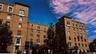 Multi-story brick facade buildings featuring decorative cornices and window surrounds