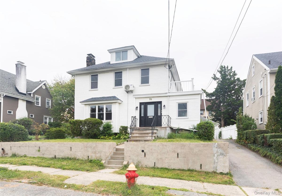 White clapboard exterior with black entry door