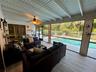 Vaulted ceilings, wood-finish flooring, plantation shutters, and a ceiling fan with integrated lighting