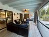 Vaulted ceiling with recessed lighting, wood-finish flooring, and white plantation shutters