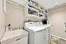 Main floor laundry room with storage and slop sink