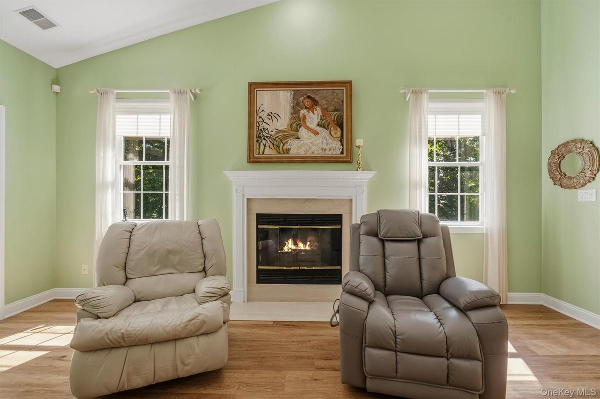Vaulted ceiling, fireplace with mantel, dual paned windows, wood-finish flooring