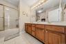 Double vanity with wood-finish cabinetry and gold-tone fixtures