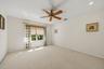 Carpeted room featuring a ceiling fan, recessed lighting, and ample natural light from a double window