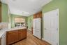 Kitchen featuring wood-finish flooring, wood cabinetry with gold-tone hardware, a tiled backsplash, and recessed lighting