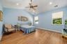Vaulted ceiling with recessed lighting and a ceiling fan, wood-finish flooring, and multiple windows with privacy blinds