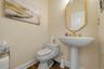 Wood-finish flooring, pedestal sink, and gold-finish fixtures