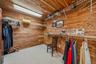 Wood-paneled walls and ceiling, carpeted flooring, and extensive wire shelving