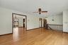 Living room with hardwood floors leading to dining room and hallway