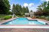 In-ground swimming pool featuring a slide, broad entry steps, and surrounding concrete decking