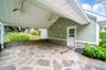 Covered outdoor patio featuring a flagstone surface, stone retaining wall, and two ceiling fans. Perfect for outdoor kitchen!