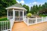 Screened gazebo with a multi-level deck, white baluster railings, and a built-in water feature