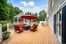 Expansive outdoor deck with a screened gazebo,  and dual sliding glass doors to kitchen area.
