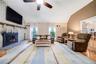 Vaulted ceiling, wood-finish flooring, white brick fireplace, ceiling fan, and French doors