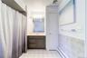 White tile flooring and a shower can be found in en-suite