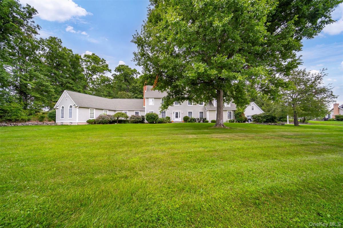 Expansive green lawn with mature trees.