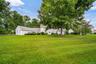 Expansive green lawn with mature trees.