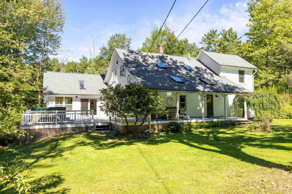 Exterior siding, covered front porch, skylights, pitched roof, and outdoor deck