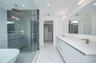 Elegant bathroom with lighted mirrors and lamps matching the brass fixtures