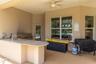The outdoor kitchen has a built-in grill, sink, and fridge.