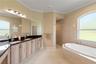 Primary bathroom with ample counter space, double sinks and granite counters. The walk-in shower and soaking tub are pictured here. There is also a se