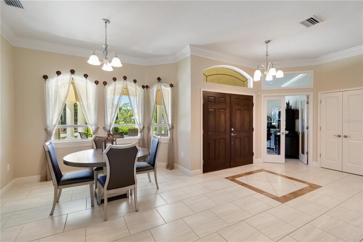Formal dining room, foyer area, office (with the glass doors) and closet to the right. Notice the transom windows and arches. There are porcelain tile