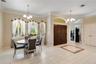 Formal dining room, foyer area, office (with the glass doors) and closet to the right. Notice the transom windows and arches. There are porcelain tile