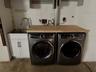 Laundry facilities are located in the garage with a sink and storage.