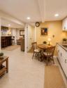 Finished lower level featuring recessed lighting, tile flooring, a kitchenette with white cabinetry, and a wet bar area with a built-in counter
