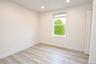 Bedroom with a window, recessed lighting and wood-look plank flooring.