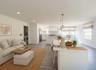 Virtually staged. Open-concept living room and kitchen with center island, pendant lighting and multiple windows.