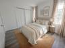Virtually staged. Primary bedroom with double closets, window and wood-look flooring.