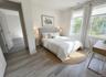 Virtually staged. Bedroom with closet and window, shown with a bed and desk area.