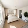Virtually staged. Bedroom with window, doorway to the hall and wood-look flooring.