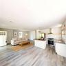 Virtually staged. Open-concept living area and kitchen with island and wood-look flooring throughout.