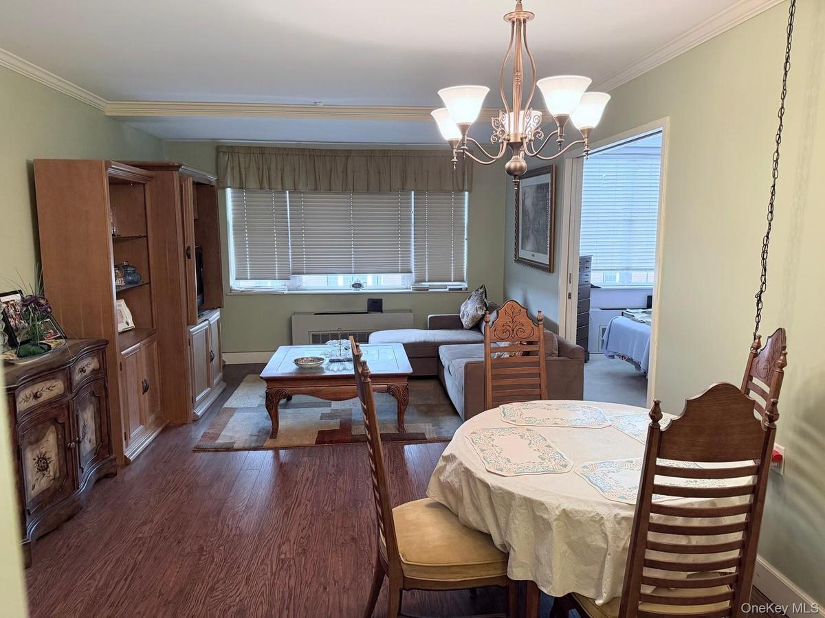 Spacious open layout living room/dining room with view of the courtyard and heated swimming pool