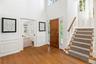Generous foyer with pocket doors to family room, multiple windows and the unique turret with staircase to second floor