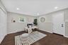 Huge office in lower level--Dark wood-finish flooring, recessed lighting, double bi-fold closet doors, white paneled door, and a single-pane window