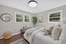 Hardwood-style flooring, light gray walls, white trim, recessed lighting fixture, and multiple windows