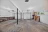 Expansive garage with concrete flooring, dual garage doors, built-in shelving, and transom windows