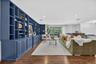 Expansive built-in shelving with lower cabinetry, recessed lighting, wood-finish flooring, and large windows