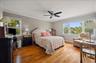 Primary bedroom with oak floors and wall of windows