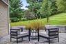 Patio featuring paver flooring, a stone retaining wall, and verdant landscaping