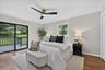 With private deck, Hardwood flooring, light gray walls, sliding glass door to exterior deck, ceiling fan with integrated lighting, and a single window